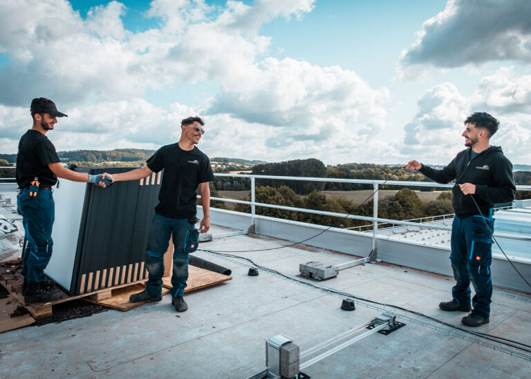 Team bei der Installation einer Solaranlage mit Sicherheitsausrüstung